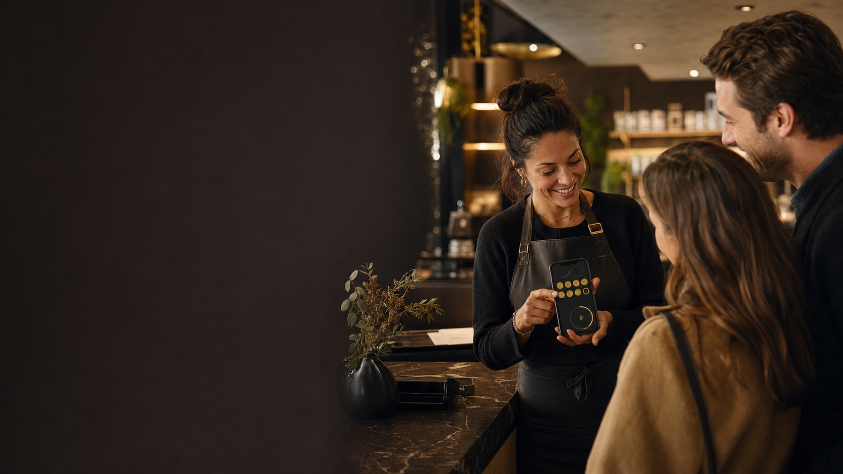 Business owner showing customers a digital loyalty card on a smartphone